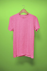 Pink umbrella hanging on leaf against green background