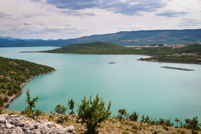 Scenic view of lake by mountains against sky