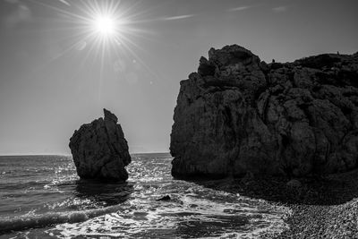 Rock formation in sea against sky