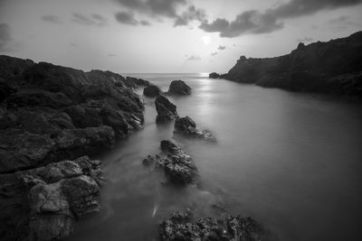 Rock formations in sea against sky