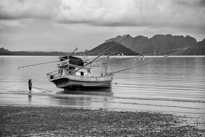 Boats in sea against cloudy sky