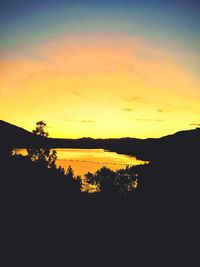 Scenic view of lake against orange sky