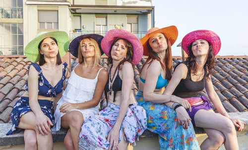 Portrait of female friends sitting on rooftop