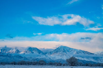 Scenic view of snowcapped mountains against blue sky