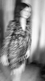 Blurred motion of woman standing against wall