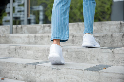 Low section of woman walking on footpath