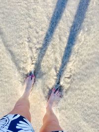 Low section of man on sand at beach