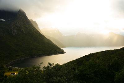 Scenic view of river and mountains against sky