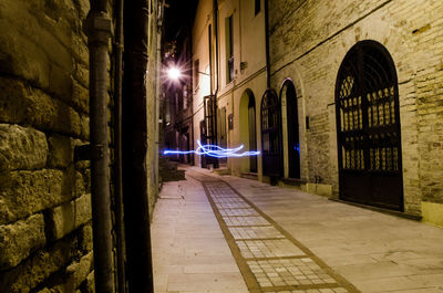 Street amidst buildings in city at night