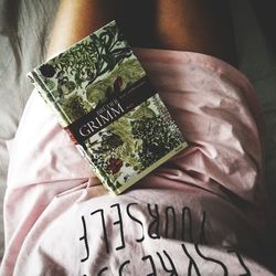 High angle view of person holding paper with tattoo on bed