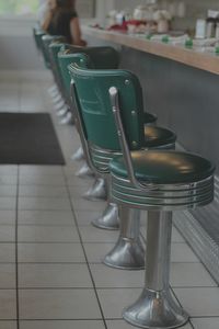 Green chairs arranged by table in cafe