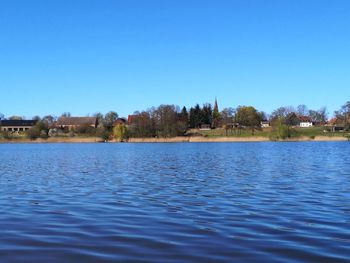 Scenic view of lake against clear blue sky