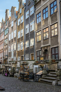 Empty chairs and tables against buildings in city