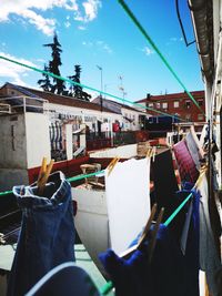 Clothes hanging on street in city against sky