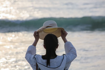 Rear view of woman standing on beach