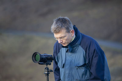 Mature man looking at digital video camera