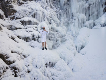 Full length of man standing on snow covered land