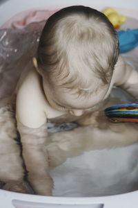 High angle view of baby girl sitting in bathtub