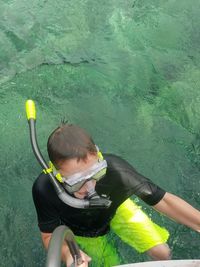 High angle view of scuba diver by railing at riverbank