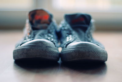 Close-up of shoes on hardwood floor at home