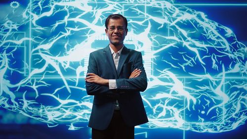 Portrait of businessman standing against wall