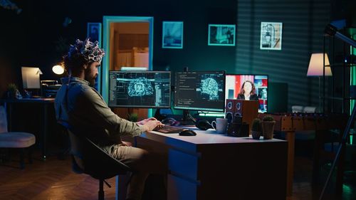 Rear view of woman using laptop at home