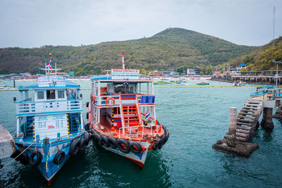 Boats moored in sea against sky