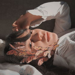 Portrait of woman lying down on bed at home