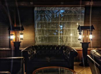 Empty chairs and tables in illuminated room