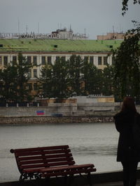 Rear view of people walking on river in city