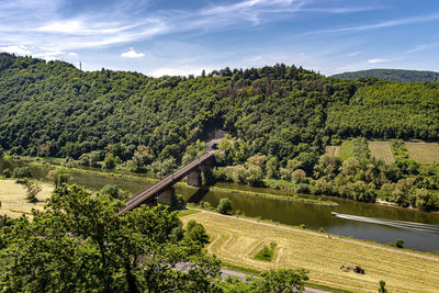 The steel truss structure of the railway bridge seen from above, in the background there are hills.