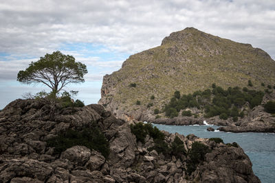 Rock formations by sea against sky