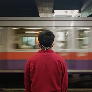 Rear view of man on train at railroad station