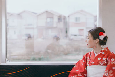 Woman looking through window in train