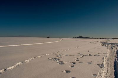 Scenic view of desert against clear blue sky