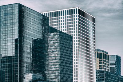 Low angle view of modern glass building against sky