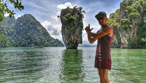 Man standing by lake against sky