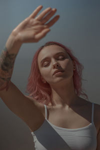 Portrait of young woman standing in front of building