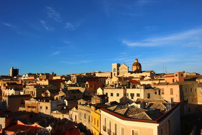 Buildings in town against blue sky
