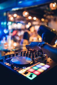 Cropped hand of dj mixing sound at nightclub