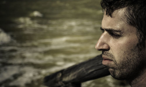 Close-up of young man looking at sea