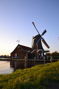 Traditional windmill on field against clear sky