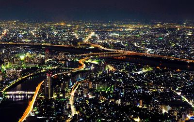 High angle view of illuminated bridge and buildings at night