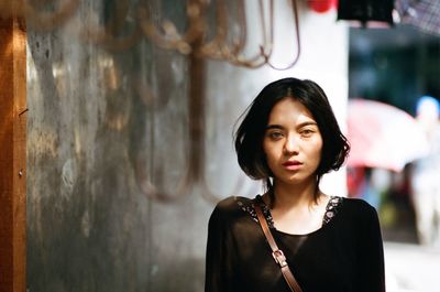 Portrait of beautiful young woman standing outdoors