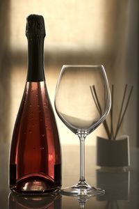 Close-up of red wine bottle and glass on table