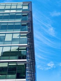 Low angle view of glass building against sky