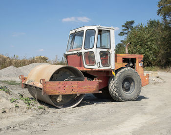 Abandoned vintage car on field against sky