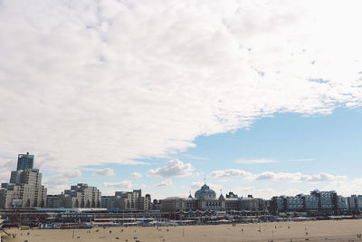 View of cityscape against cloudy sky