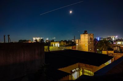 Illuminated buildings against sky at night