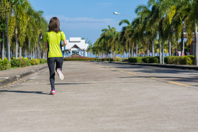 Rear view of woman running on street